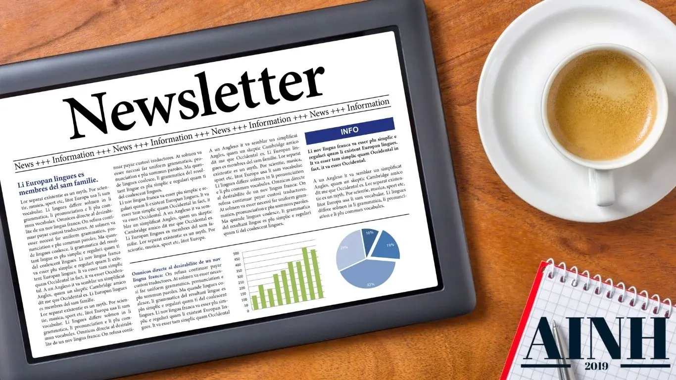 Tablette avec une gazette newsletter dedans sur une table et un café à côté